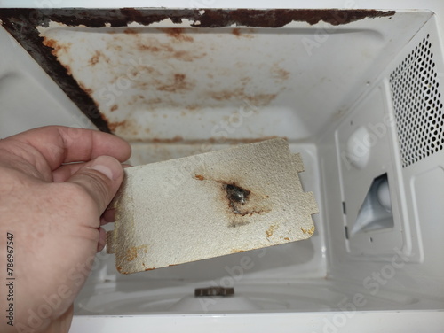 Broken burnt mica of magnetron waveguide in the microwave oven when a malfunction of the microwave oven sparks