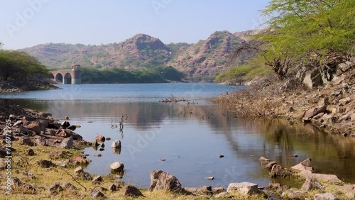 pristine lake calm water with mountain background at day from different angle video is taken at kaylana lake jodhpur rajasthan india. photo