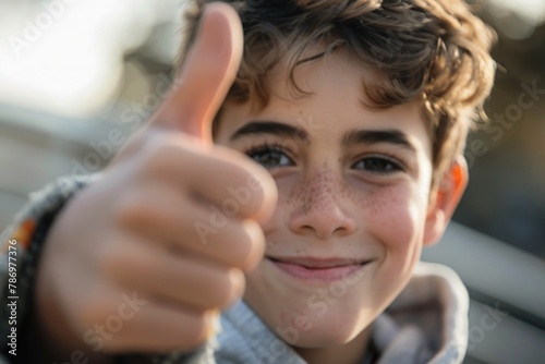 A cheerful young boy giving a thumbs up gesture. Suitable for various positive concepts