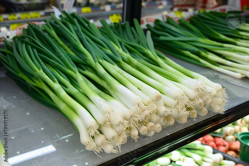 Fresh green onions on the counter of a supermarket. Selective focus.