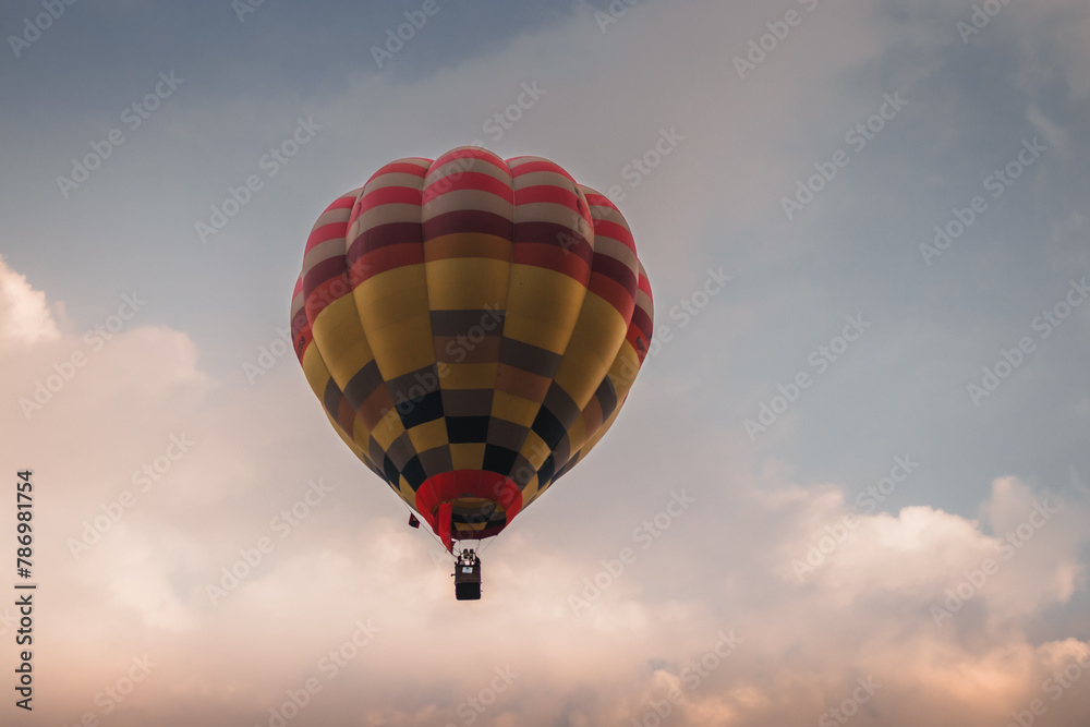 Naklejka premium A hot air balloon flying at sunset