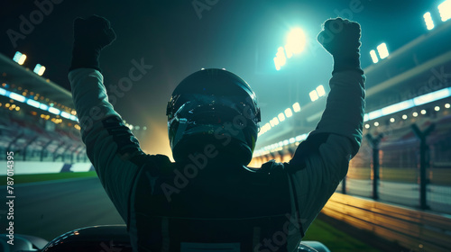 Victorious race car driver celebrating win at night on illuminated track photo