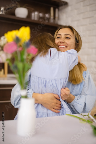 Little daughter hug her mother in mother’s day. happy family. Focus on smiling mom face. Vertical photo