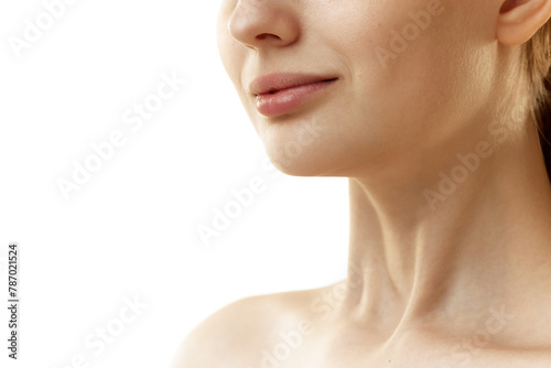 Cropped photo of young woman with well-kept, rejuvenated skin at on neckline zone against white studio background. Concept of natural beauty, organic cosmetic, spa procedures, face-care.