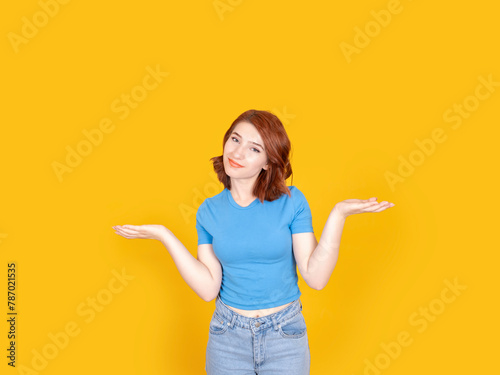 I have no idea, portrait of young caucasian red bob hair woman shrugging shoulders say I have no idea. Confused girl don't know answer. Standing over yellow studio background, isolated, copy space.
