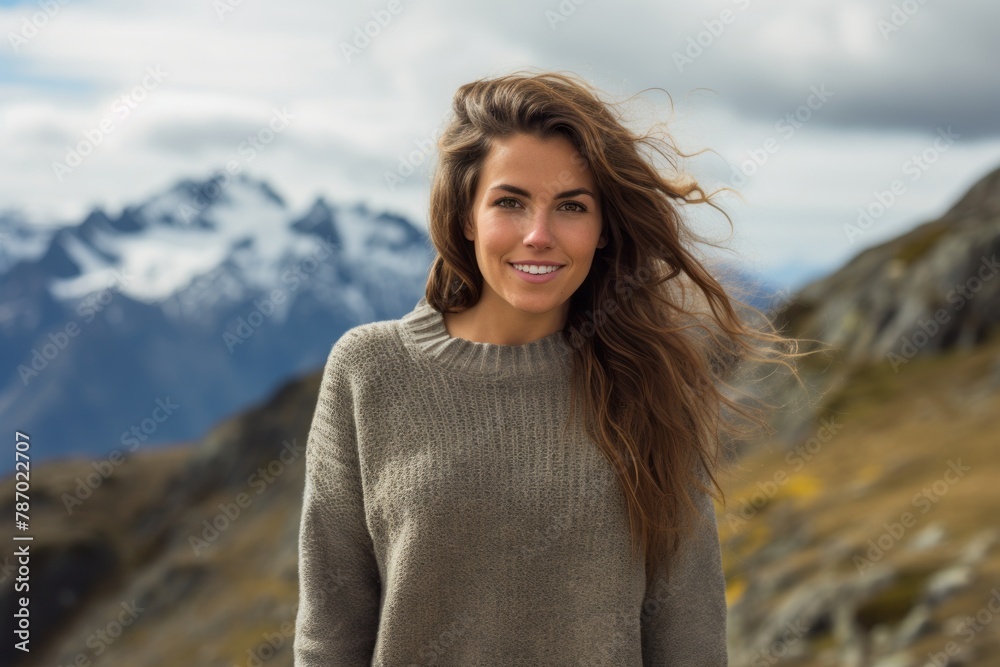 Portrait of a satisfied woman in her 30s wearing a cozy sweater isolated on panoramic mountain vista