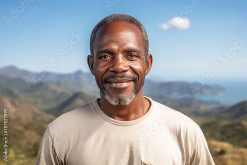 Portrait of a glad afro-american man in his 50s donning a classy polo shirt isolated in panoramic mountain vista