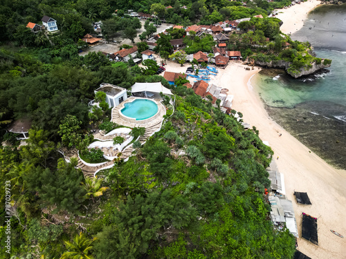 Aerial view of white colored luxury hotel or resort buildings with swimming pool in a hilltop surrounded by dense forest trees. Concept for tourism, tourist destination, vacation, tropical villa. photo