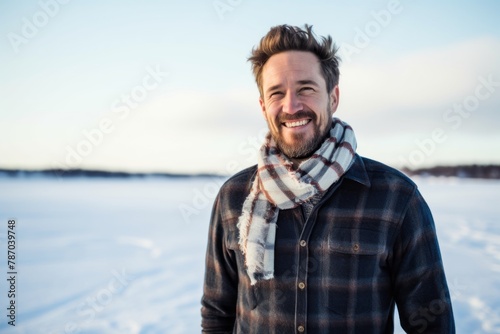 Portrait of a joyful man in his 30s wearing a simple cotton shirt while standing against backdrop of a frozen winter lake