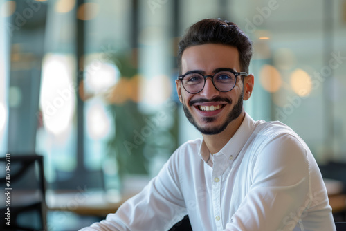 With a bright smile, a young Arab male entrepreneur radiates confidence in the professional office boardroom meeting, inspiring trust and credibility.