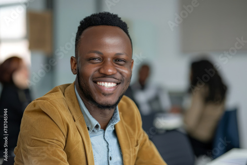 With unwavering confidence, a young African entrepreneur smiles brightly in the office boardroom meeting, signaling his readiness to drive success and innovation. photo