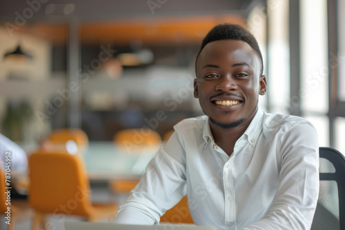 With unwavering confidence, a young African entrepreneur smiles brightly in the office boardroom meeting, signaling his readiness to drive success and innovation.