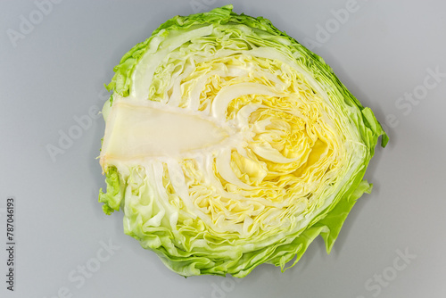 Half of young white cabbage on gray background, top view