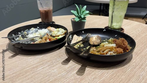 Wasted food and drink on a plate on the table. Leftover food and drink after dinner in the restaurant.
