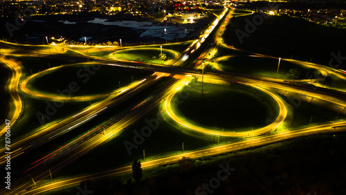 Aerial view huge multi-lane circle roundabout intersection in city traffic highway night city. Public transport commuter pollution business concept. Milan, Italy.