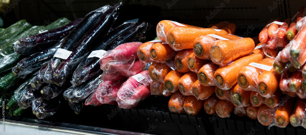 Pile of fresh carrots and eggplants in supermarket