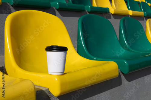 white paper cup of coffee in the stands of the stadium