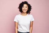 Portrait of a smiling asian woman in her 20s sporting a vintage band t-shirt isolated on soft pink background