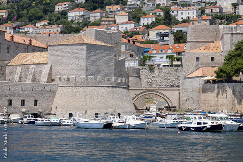 Picturesque medieval Old Port by Adriatic Sea with moored ships and Revelin Fort, Dubrovnik, Croatia photo