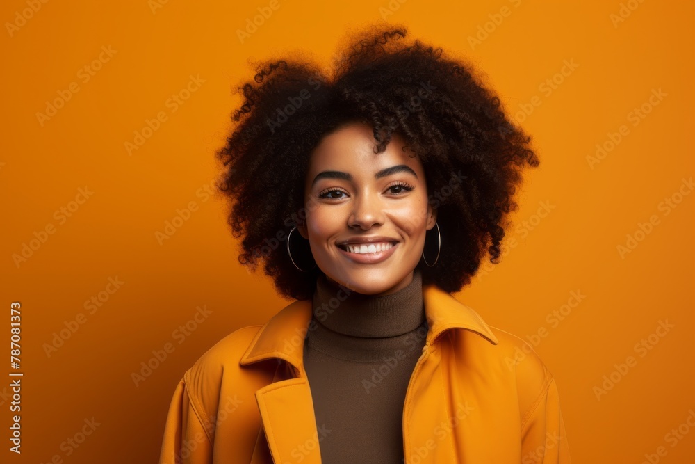Portrait of a glad afro-american woman in her 20s dressed in a water-resistant gilet in front of soft orange background Portrait of a glad afro-american woman in her 20s dressed in a water-resistant gilet in front of soft orange background