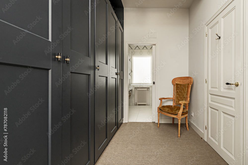 Corridor leading to a bathroom with petrol green lacquered wooden cabinets Corridor leading to a bathroom with petrol green lacquered wooden cabinets