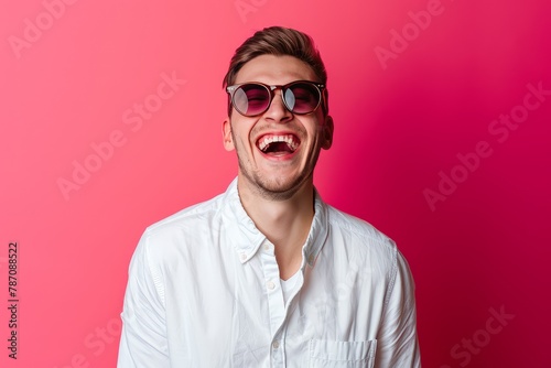 Photo of funky attarctive guy dressed white shirt dark glasses smiling having fun isolated pink color background . photo on white isolated background photo