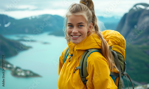 Portrait of a happy young blonde woman smiling with joy against the background of fjords high in the mountains of Norway © anatoliycherkas