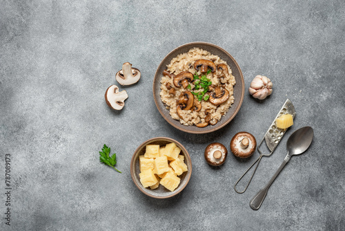 Risotto with brown champignon mushrooms on a gray grunge background. Italian dish. Top view, flat lay, copy space.