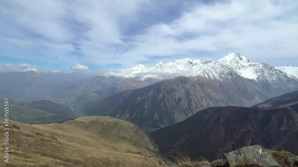 Archonsky Pass. The pass connects the Kurtatinsky gorge with the Alagirsky. Alanya, view of the mountains of the North Caucasus, peaks covered with snow. Sunny day, blue sky with a slight haze. 4К Archonsky Pass. The pass connects the Kurtatinsky gorge with the Alagirsky. Alanya, view of the mountains of the North Caucasus, peaks covered with snow. Sunny day, blue sky with a slight haze. 4К