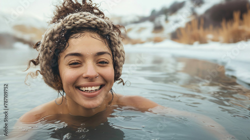 Smiling young woman swimming in hot spring in winter