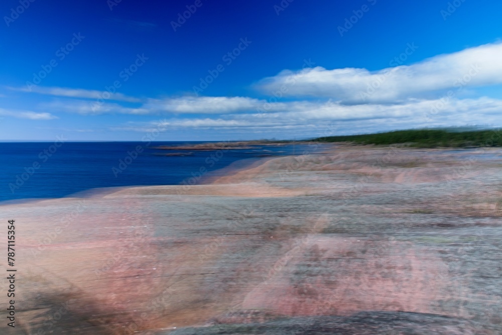 Intentional camera movement (ICM) image of a dream like background of rocky seashore created by motion blur.