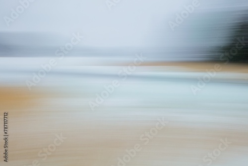 Intentional camera movement (ICM) image of seashore with reeds and ground covered with snow in winter created by motion blur.
