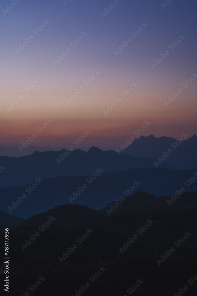 Fototapeta premium nature traveling with orange sky and layer of mountain with sunrise background