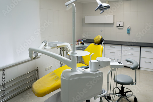 a dental office white sterile ready for robots yellow chair for the patient and white equipment photo