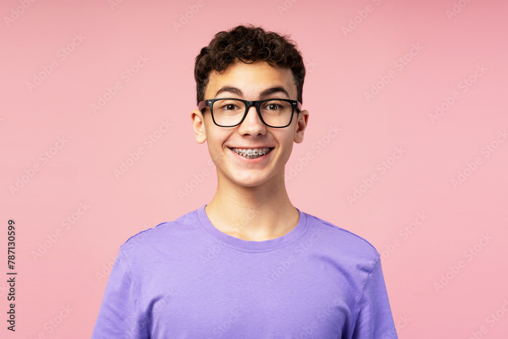 Portrait of smiling happy boy, teenager with braces wearing eyeglasses looking at camera Portrait of smiling happy boy, teenager with braces wearing eyeglasses looking at camera