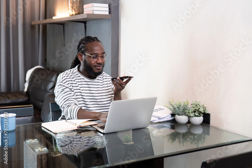 Professional man working remote from home with technology. African American male has a business meeting on an audio call phone