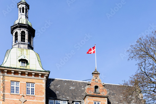 Photography Danish flag on the roof of a building against a blue sky.