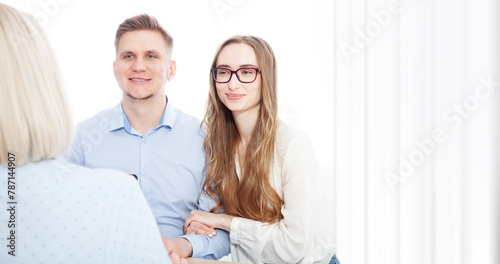 Young couple, eager to sign a bank loan agreement, meets with their broker agent.
