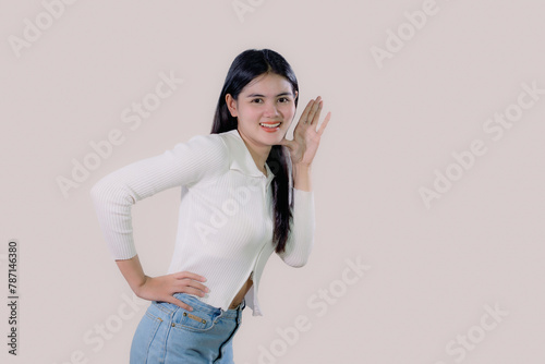 young Asian woman with open mouths raising hands shouting good news isolated on white background.