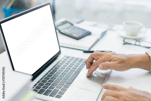 Man using laptop working at home with blank white desktop screen. Mockup screen copy for use