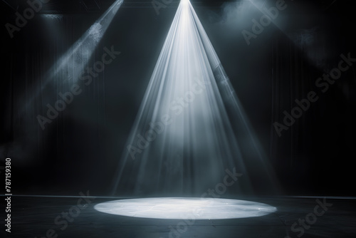 Dimly lit stage background, a bright spotlight, white text fading in