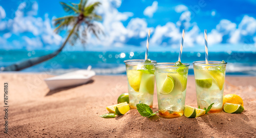 Tasty and fresh lemonade with ice on sandy beach.