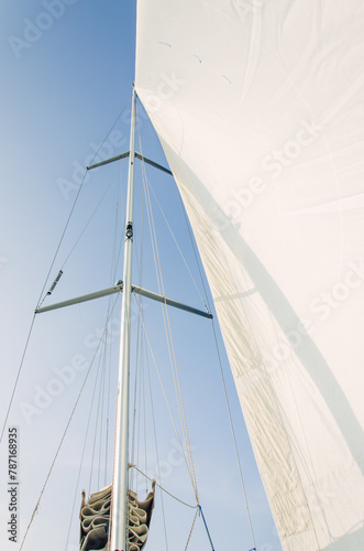 White sail genoa in the wind on the sailboat, blue sky background, windy day