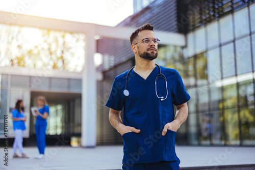 Portrait of male nurse at hospital. Portrait of a smiling doctor. Doctor with stethoscope standing, crossed arms, isolated on bright background. Portrait of a friendly doctor smiling at the camera. photo