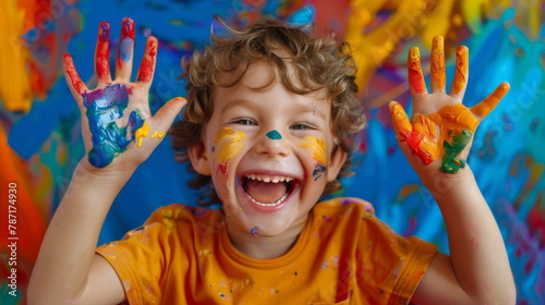 Child with colorful painted hands, perfect for education and creative play themes.