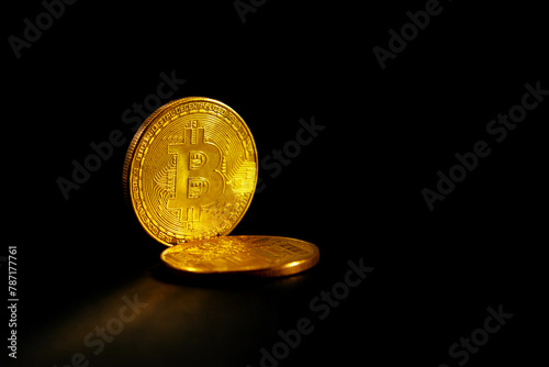 Two bitcoins close-up on a black background.