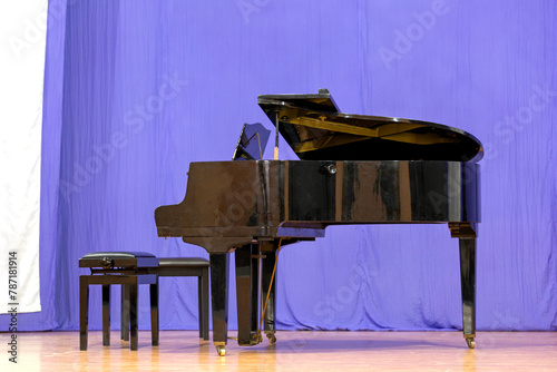 A black grand piano on stage, without a musician.