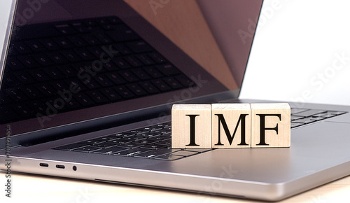 IMF word on wooden block on laptop , business concept