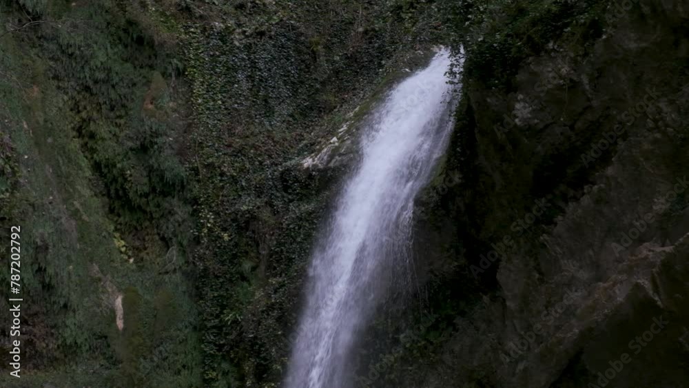 thin waterfall in the mountains in the forest, waterfall and stones covered with moss, close up, slow motion thin waterfall in the mountains in the forest, waterfall and stones covered with moss, close up, slow motion