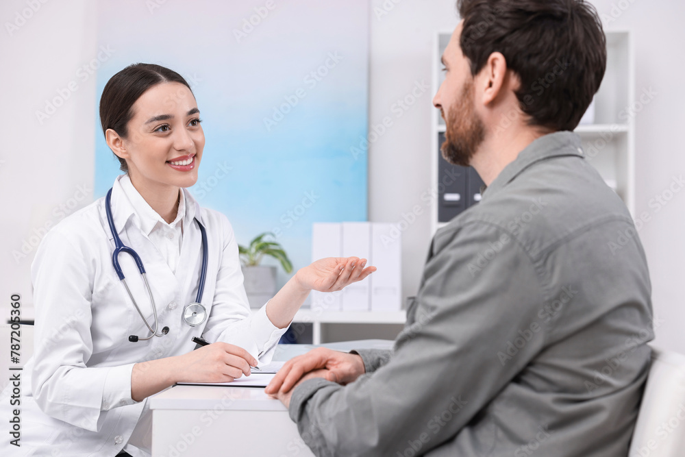 Doctor consulting patient during appointment in clinic Doctor consulting patient during appointment in clinic